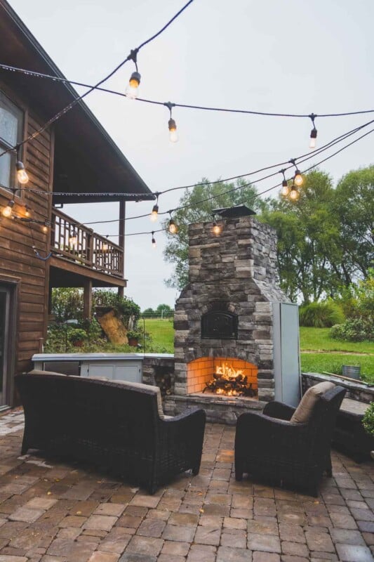 Outdoor entertaining space with a fire in the fireplace