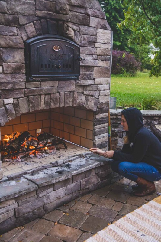 Woman roasting a marshmallow in a fireplace