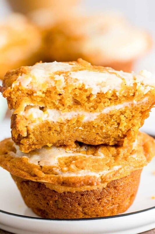 Two pumpkin cream cheese muffins stacked on top of each other
