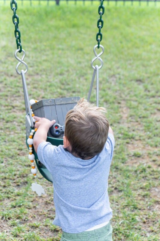 Baby getting a treasure box out of a swing