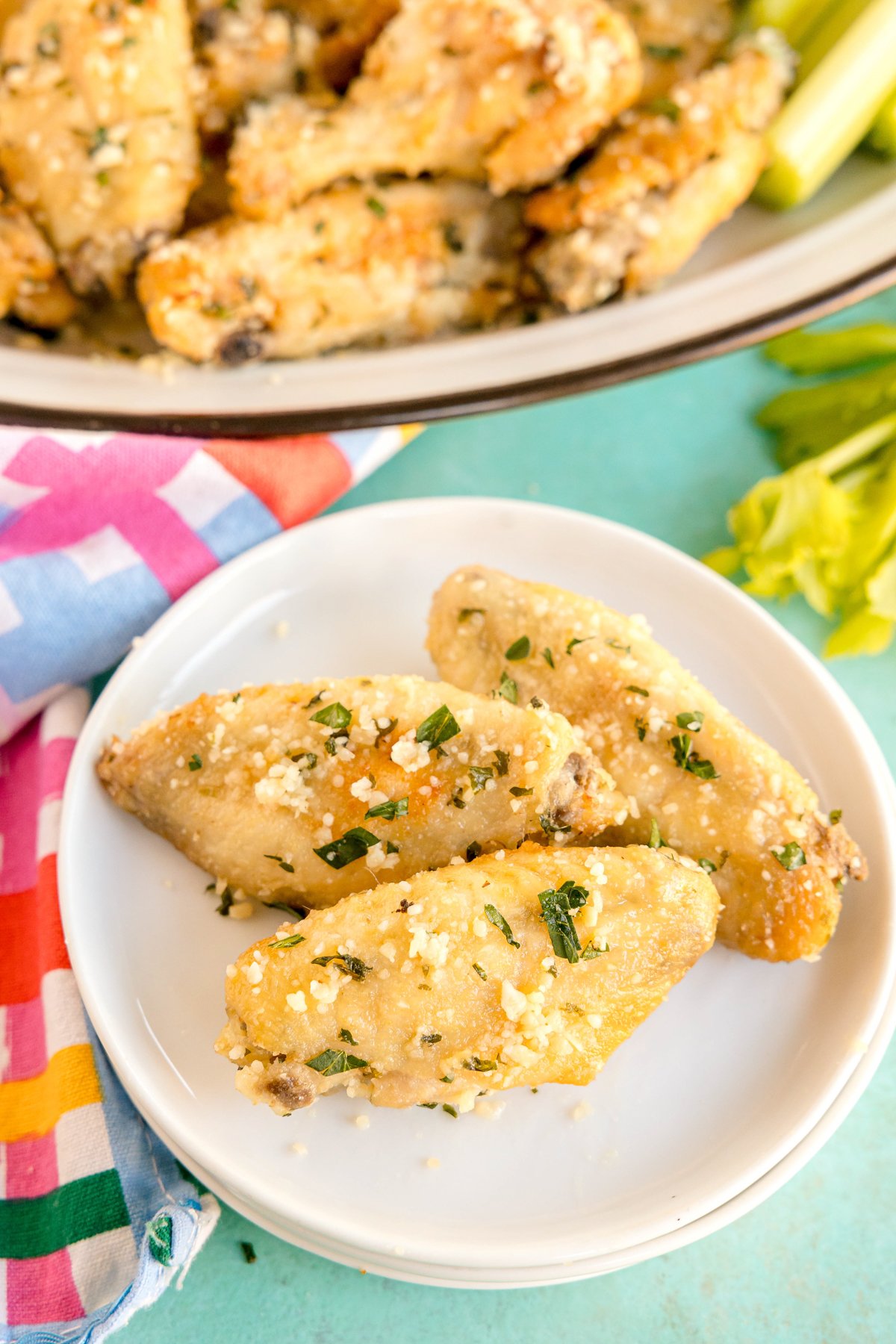 white plate with three baked parmesan garlic wings