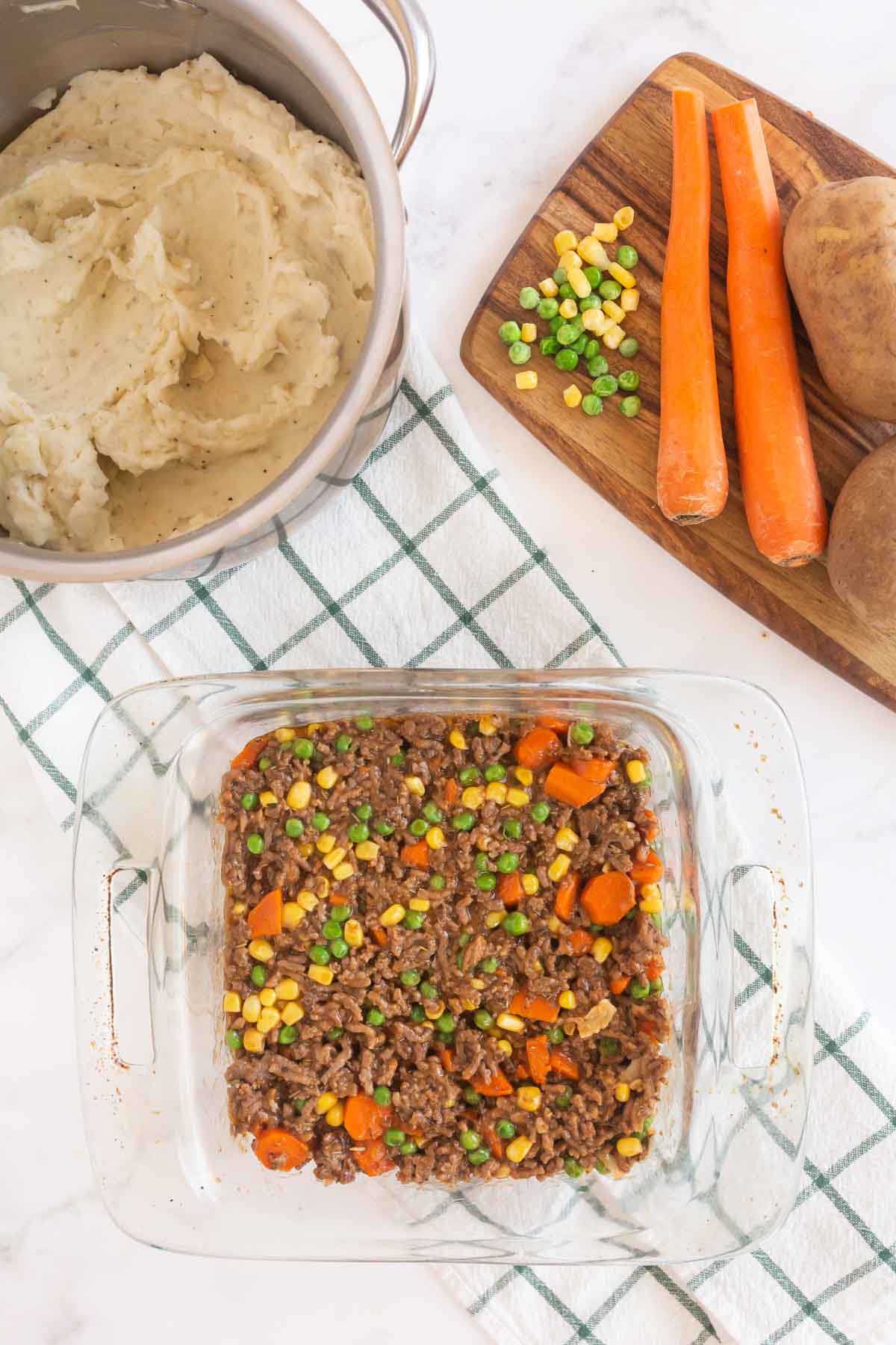 Sheperds pie filling in a square glass baking dish