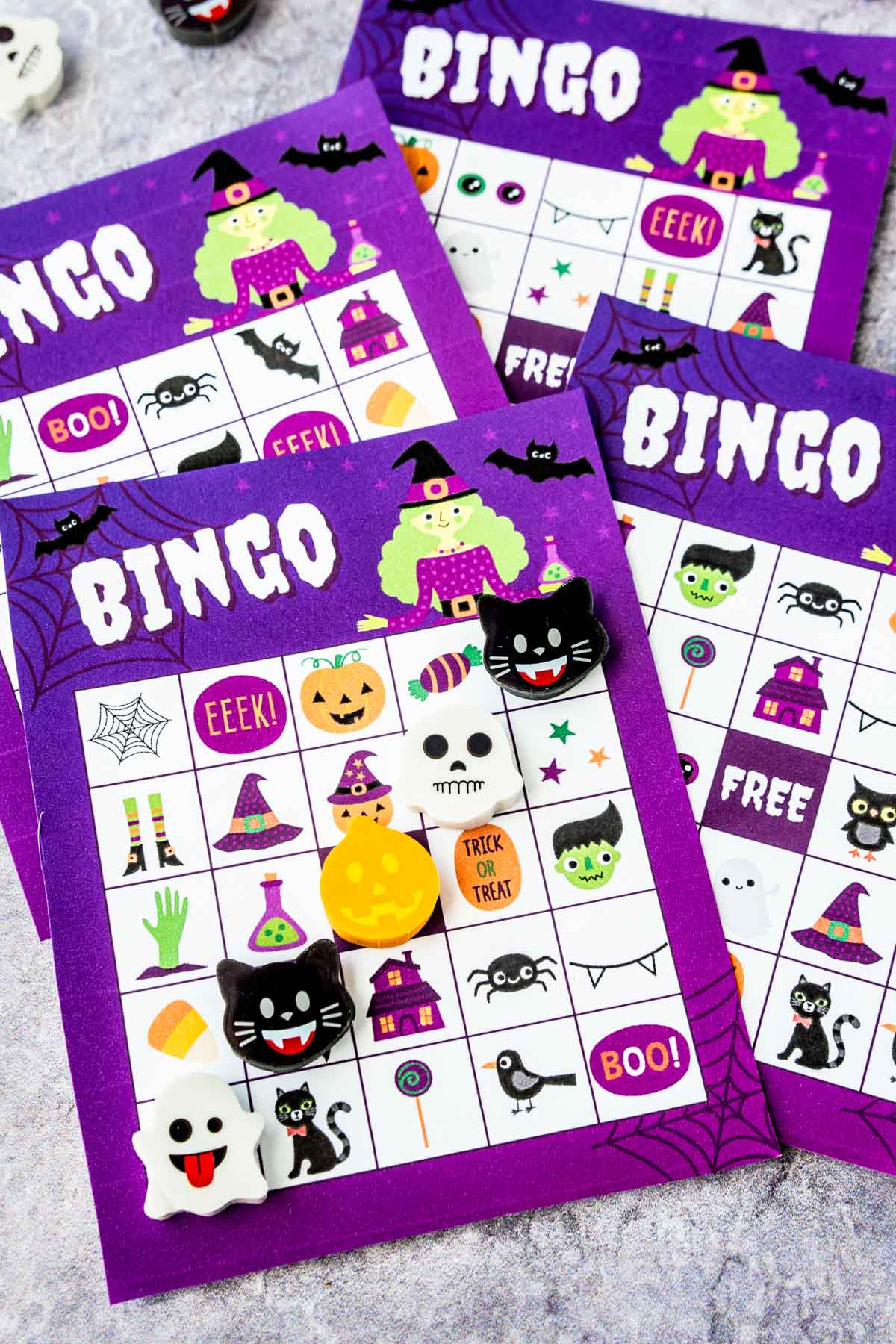 Purple Halloween bingo cards with Halloween erasers marking a bingo