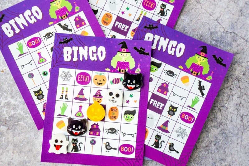 Purple Halloween bingo cards with Halloween erasers marking a bingo