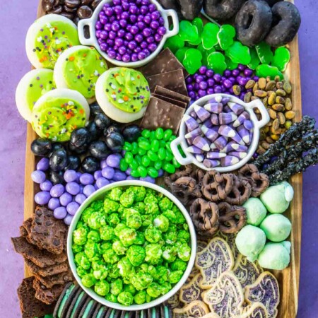 Rectangle wood tray with purple, black, and green snacks