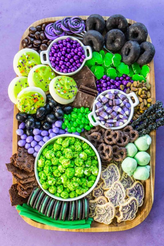 Rectangle wood tray with purple, black, and green snacks