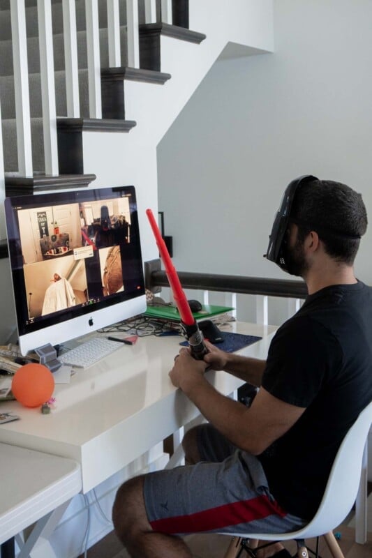 Man in a Star Wars mask sitting in front of a computer screen