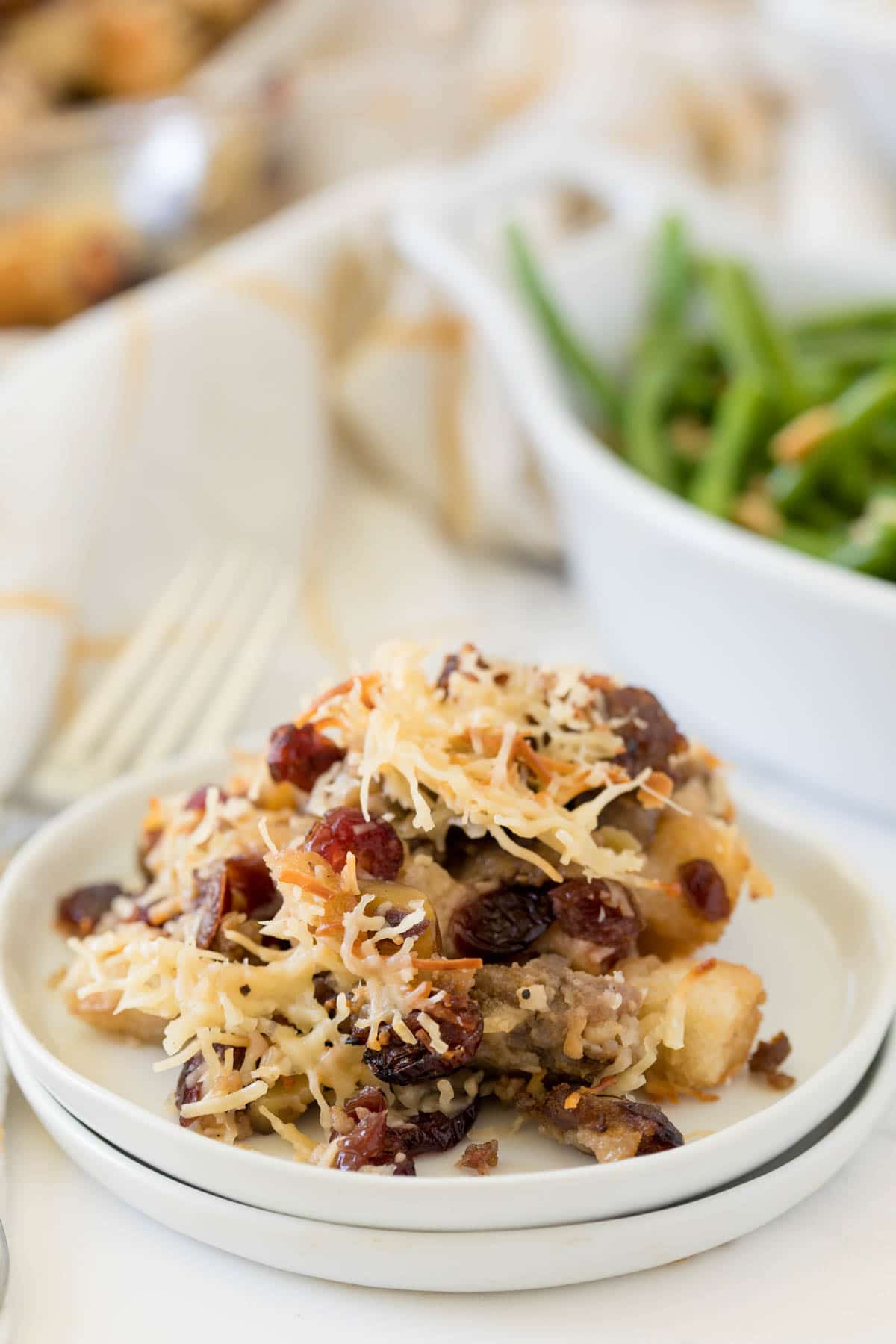 White plate with sausage stuffing and green beans in the background