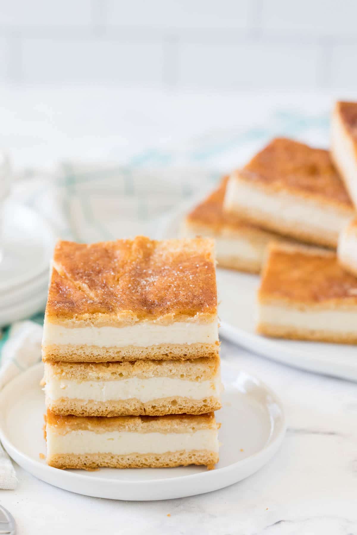 Three sopapilla cheesecake bars stacked on top of each other