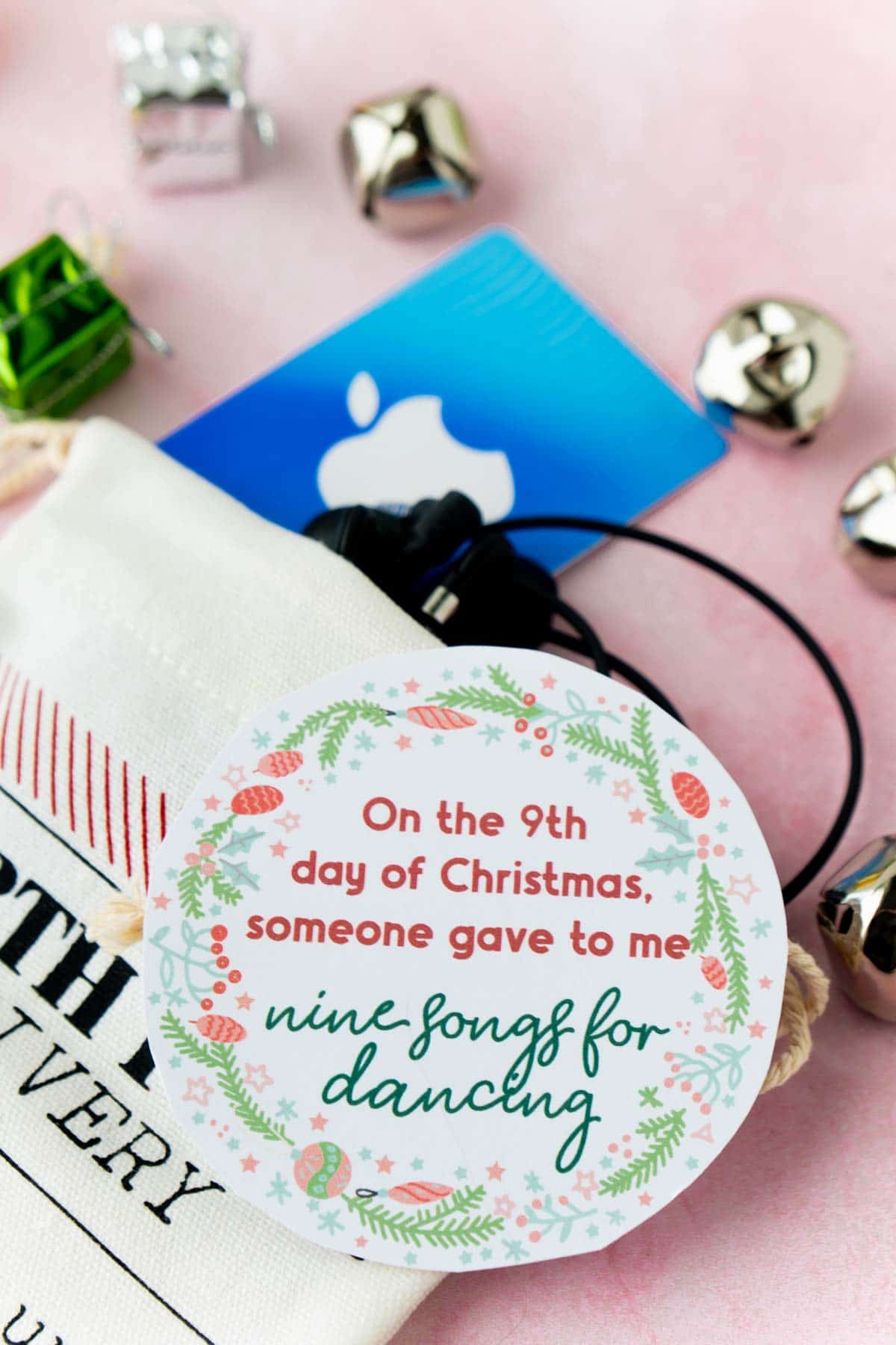 12 days of Christmas gift tags on top of a stocking with a gift card and bells