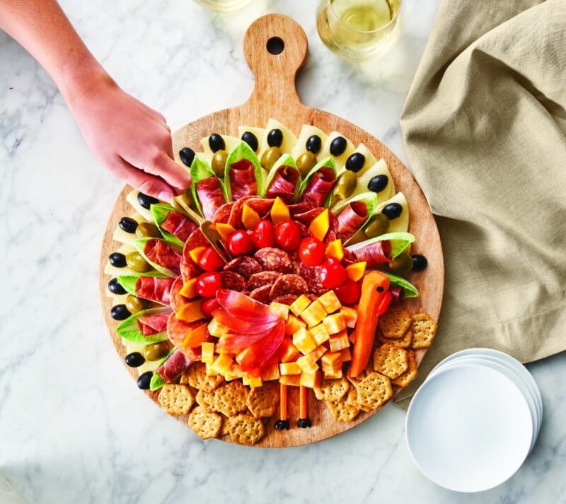 Circle charcuterie board with someone's hand