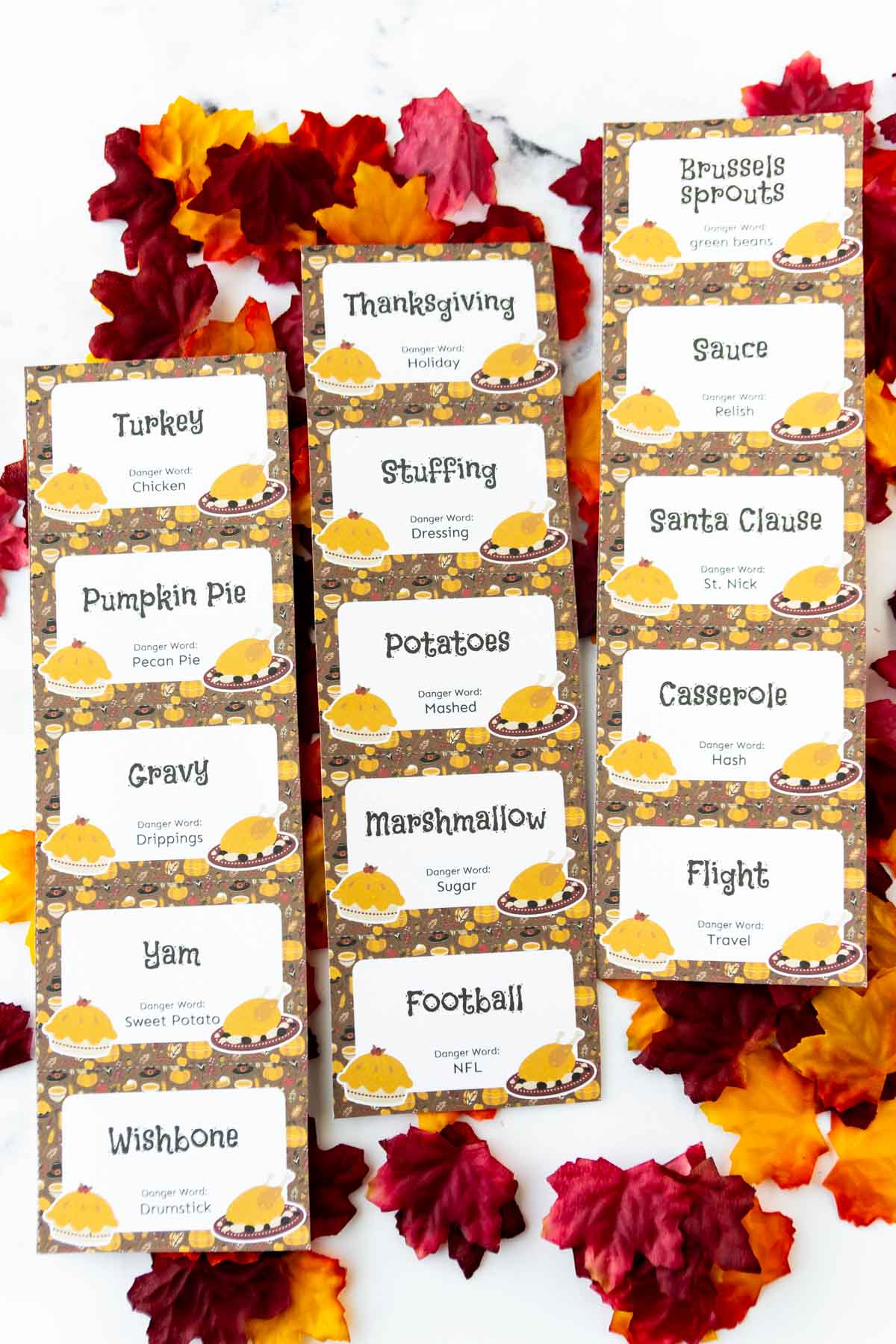 Three sheets of Thanksgiving danger words on top of plastic leaves