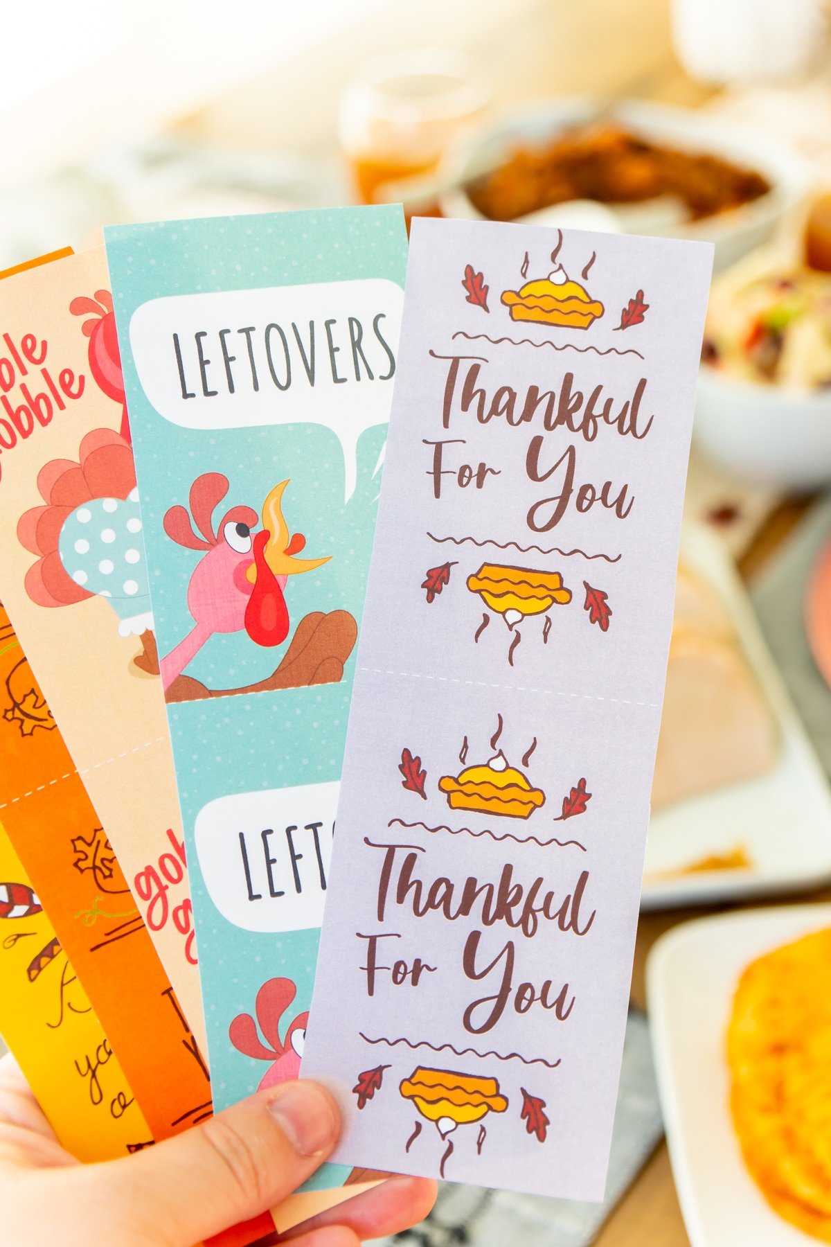 Thanksgiving gift tags being held by a woman's hand