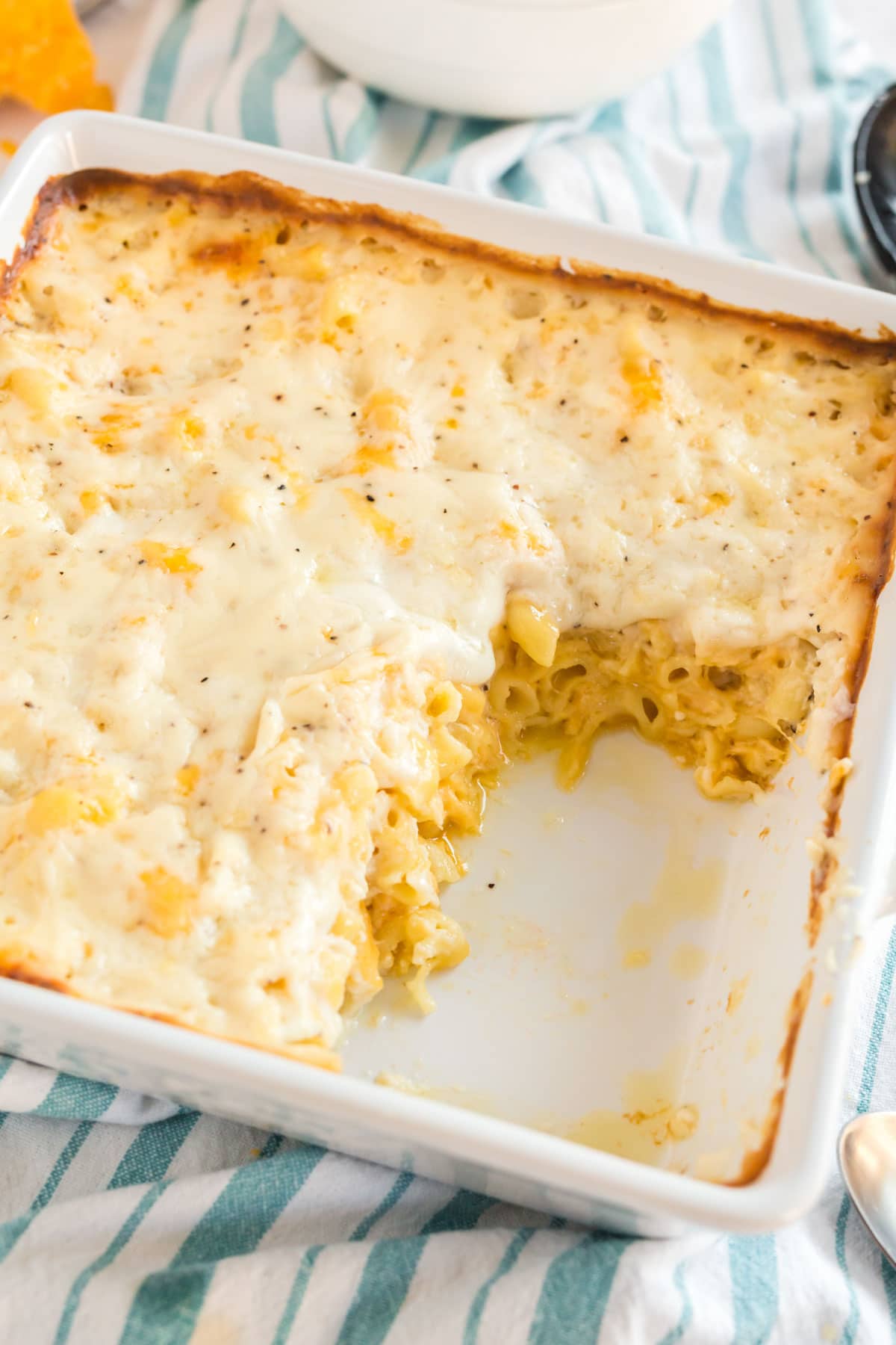 A pan of baked macaroni and cheese with a scoop taken out