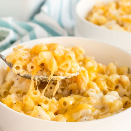 A bowl of baked macaroni and cheese with a spoon in it