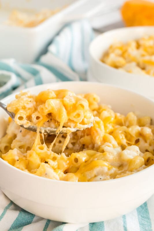 A bowl of baked macaroni and cheese with a spoon in it