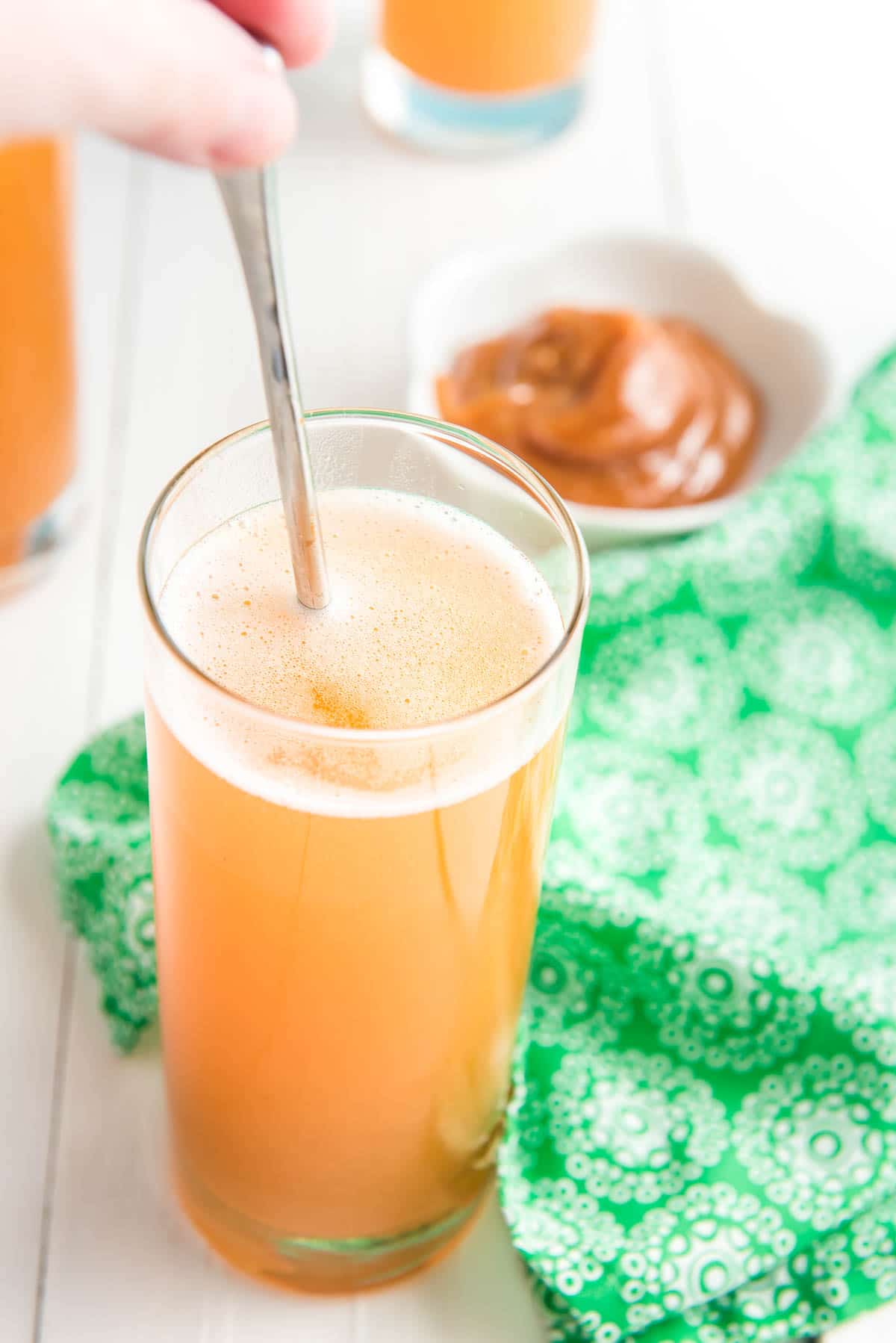 Stirring a caramel apple drink with a spoon