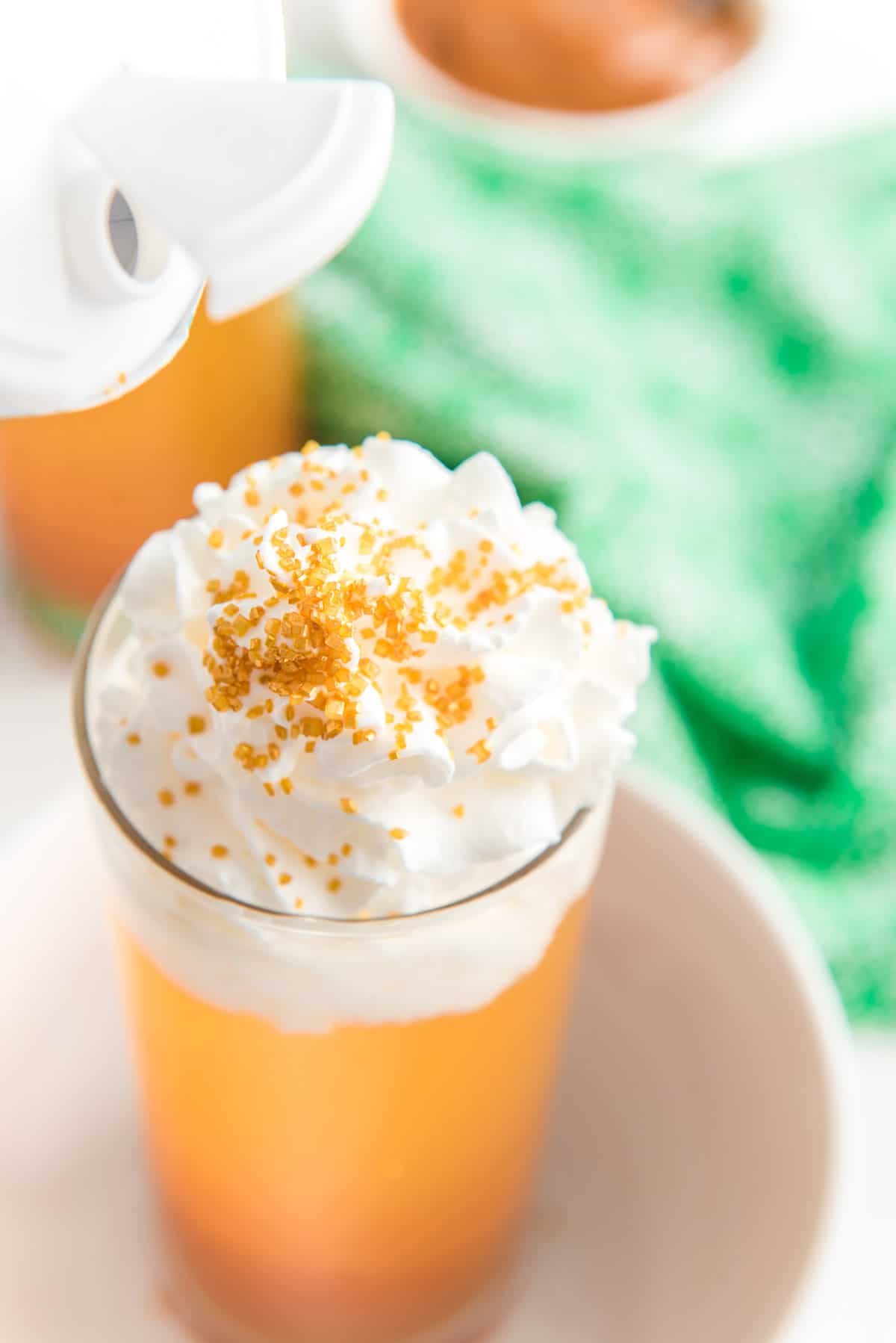 Whipped cream and sprinkles on top of a caramel apple drink