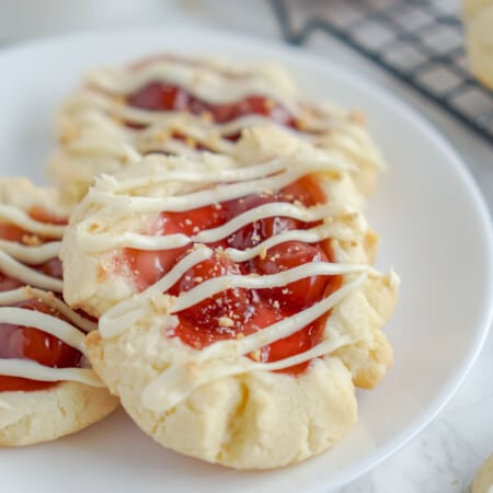 A white plate with cherry cheesecake cookies on it