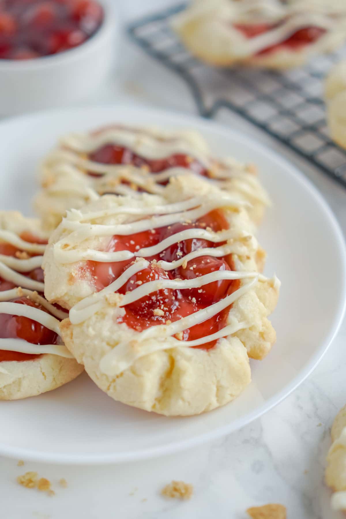 A white plate with cherry cheesecake cookies on it