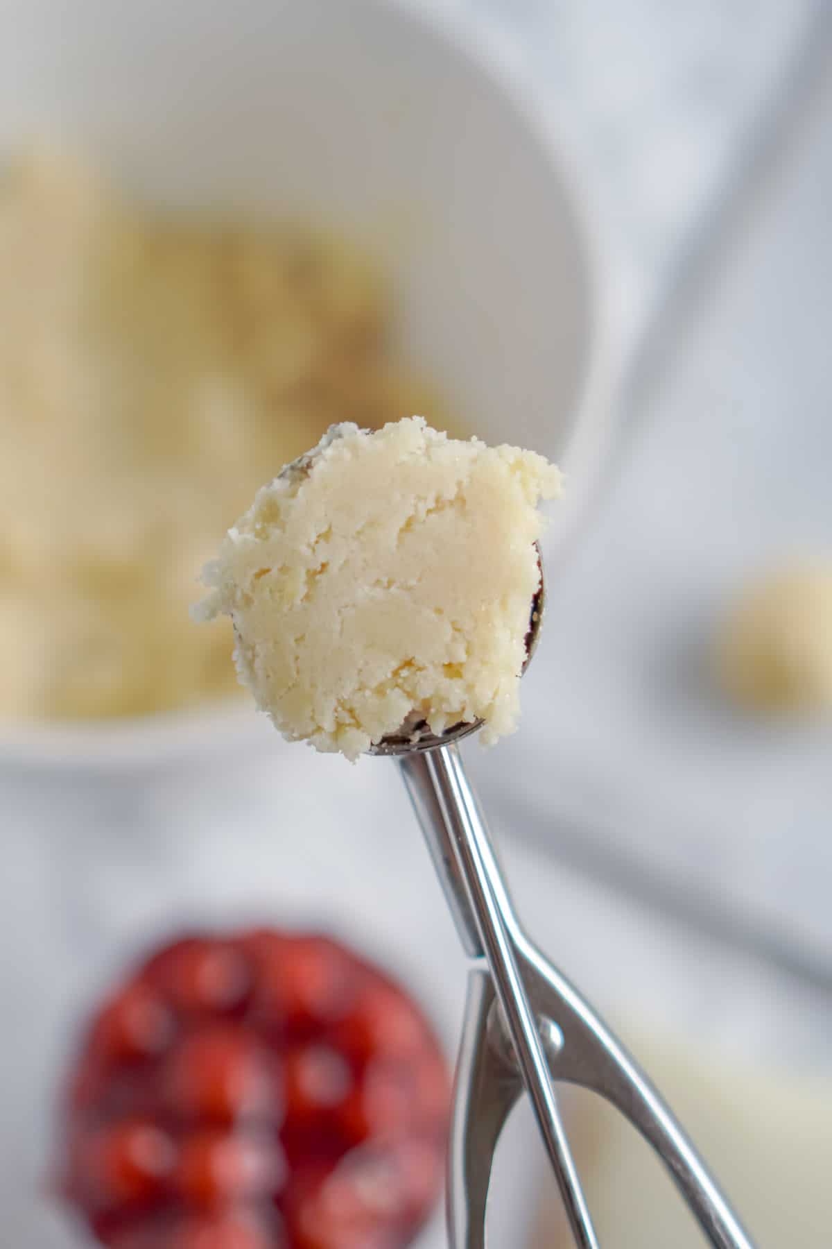 Cookie scoop with cherry cheesecake cookies dough in it