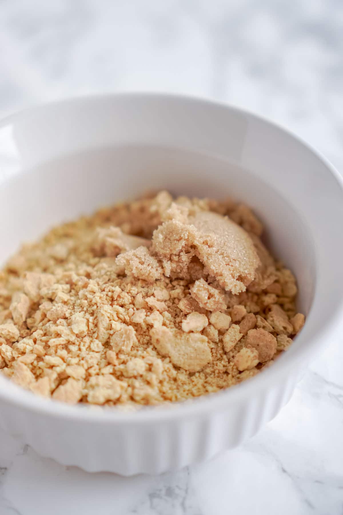 White bowl with graham cracker crumbs and brown sugar