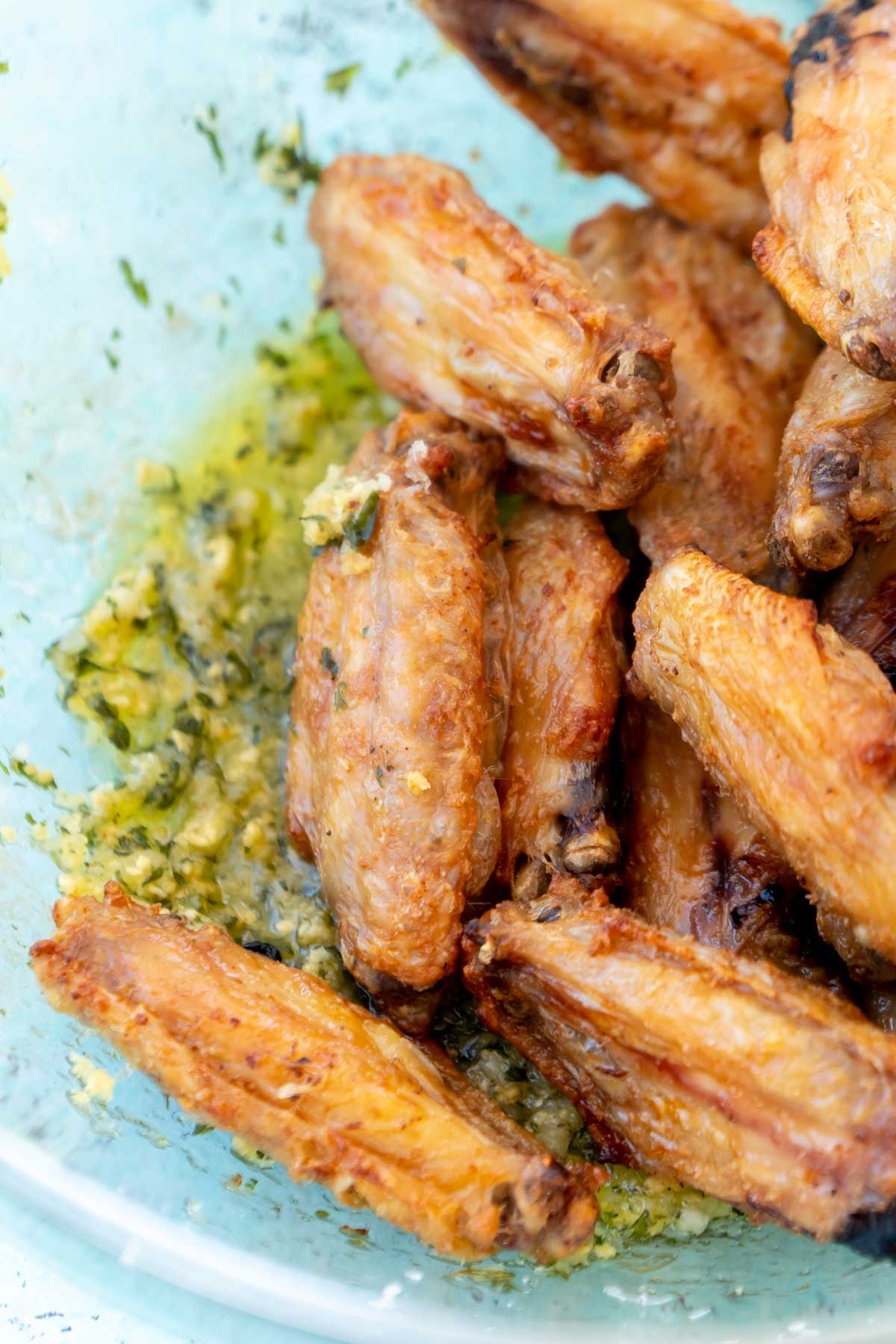 Wings in a glass bowl with garlic parmesan sauce