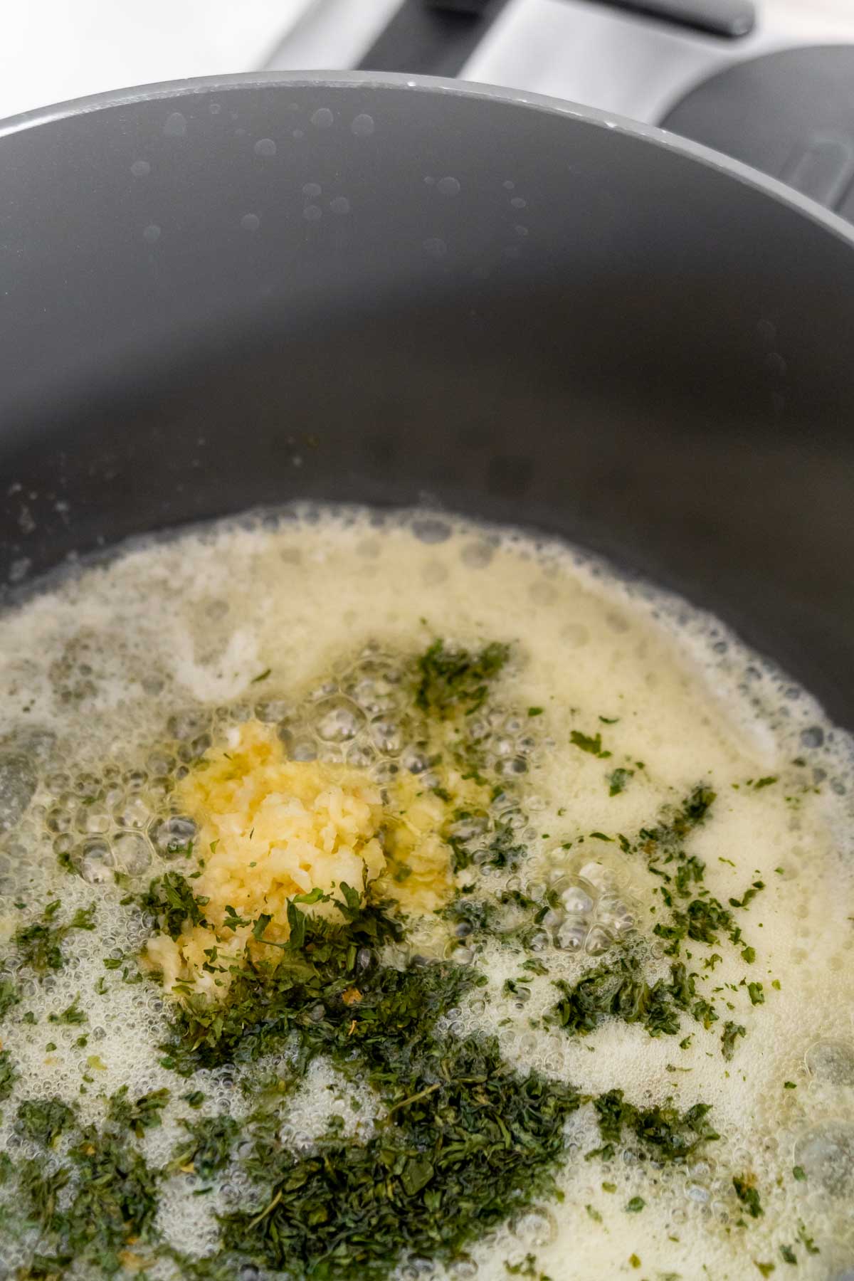 Melted butter with garlic and parsley in a pan