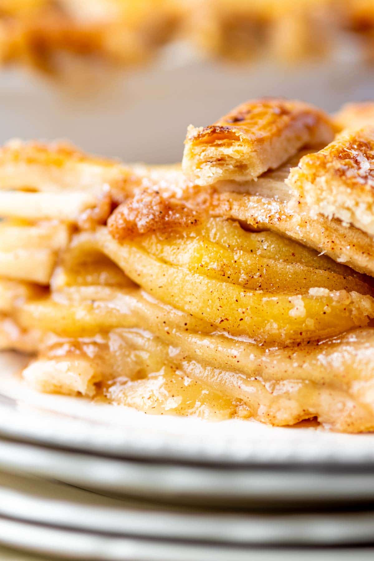 Piece of homemade apple pie on a stack of plates