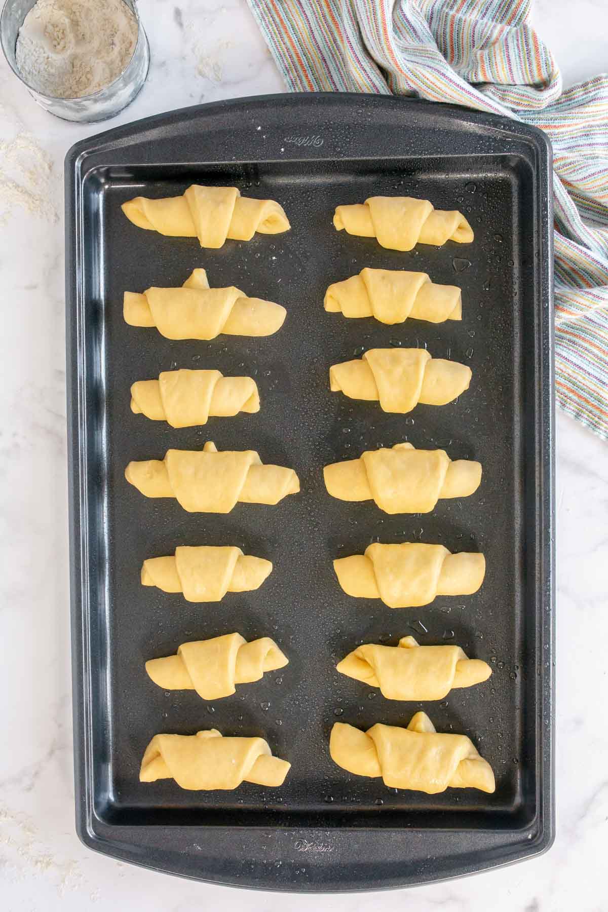 Homemade crescent rolls on a baking sheet