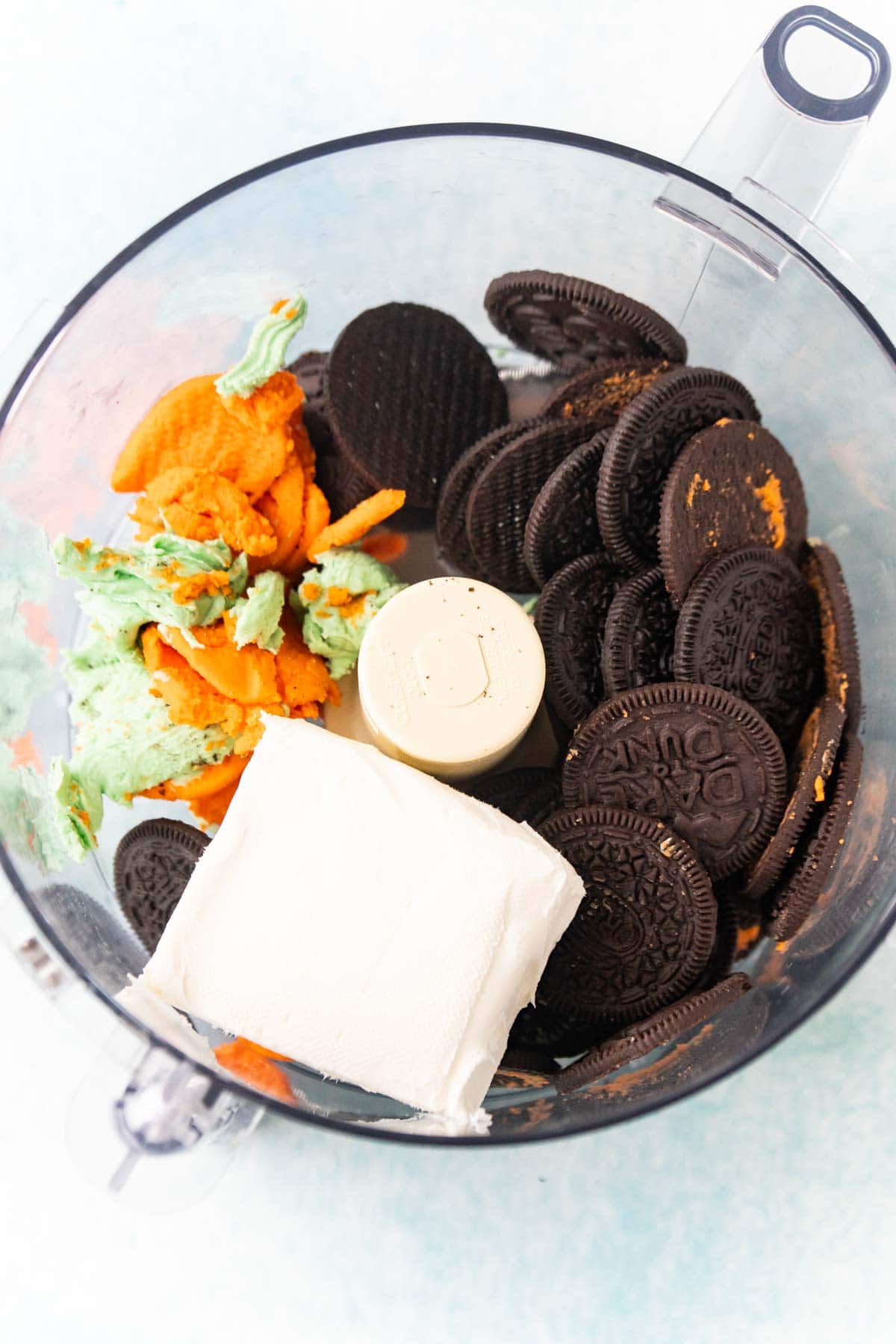Oreo cookies, cream cheese, and filling in a food processor 