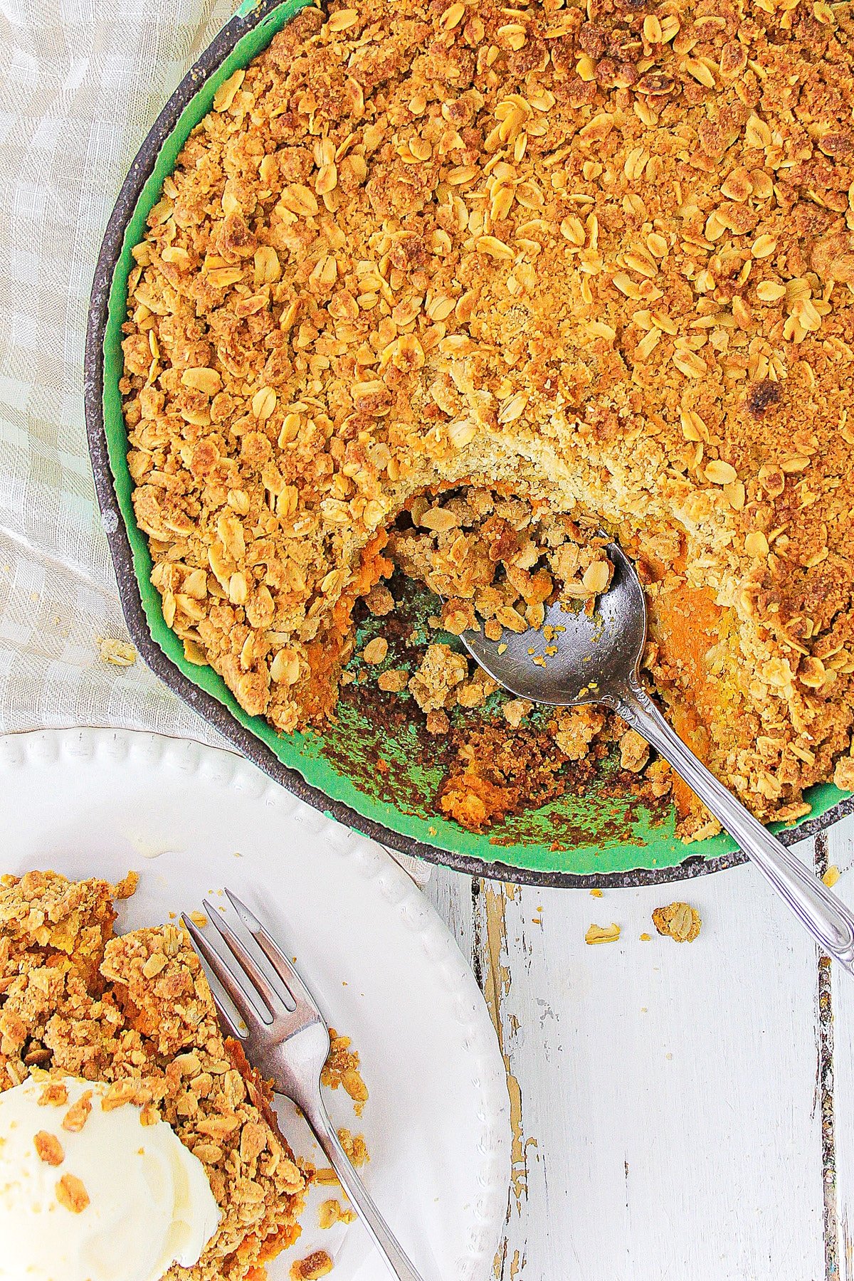 Cast iron skillet with pumpkin crisp and a spoon