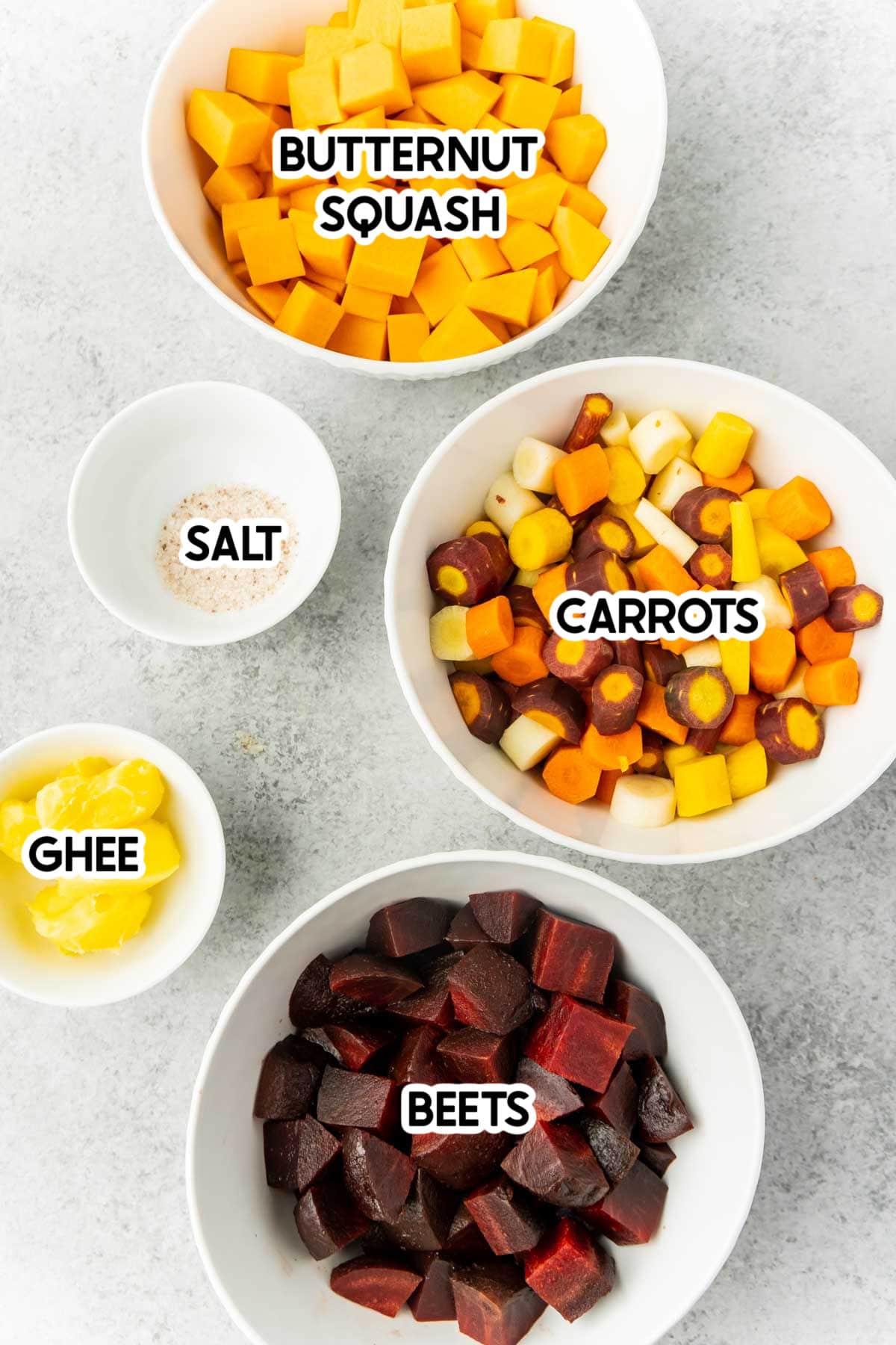 Root vegetables in white bowls with labels on top