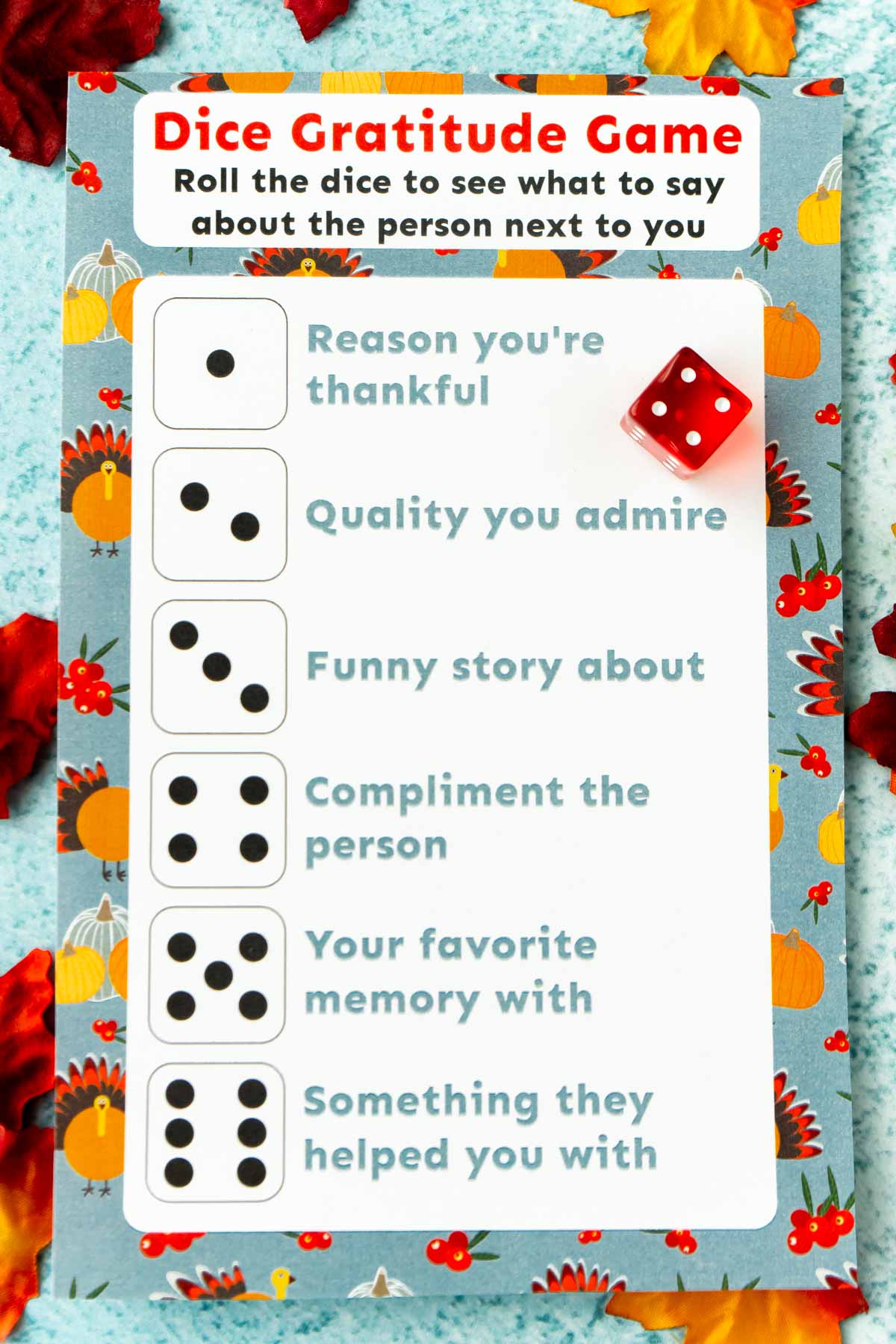 Printed out Thanksgiving dinner game with a dice and leaves around it