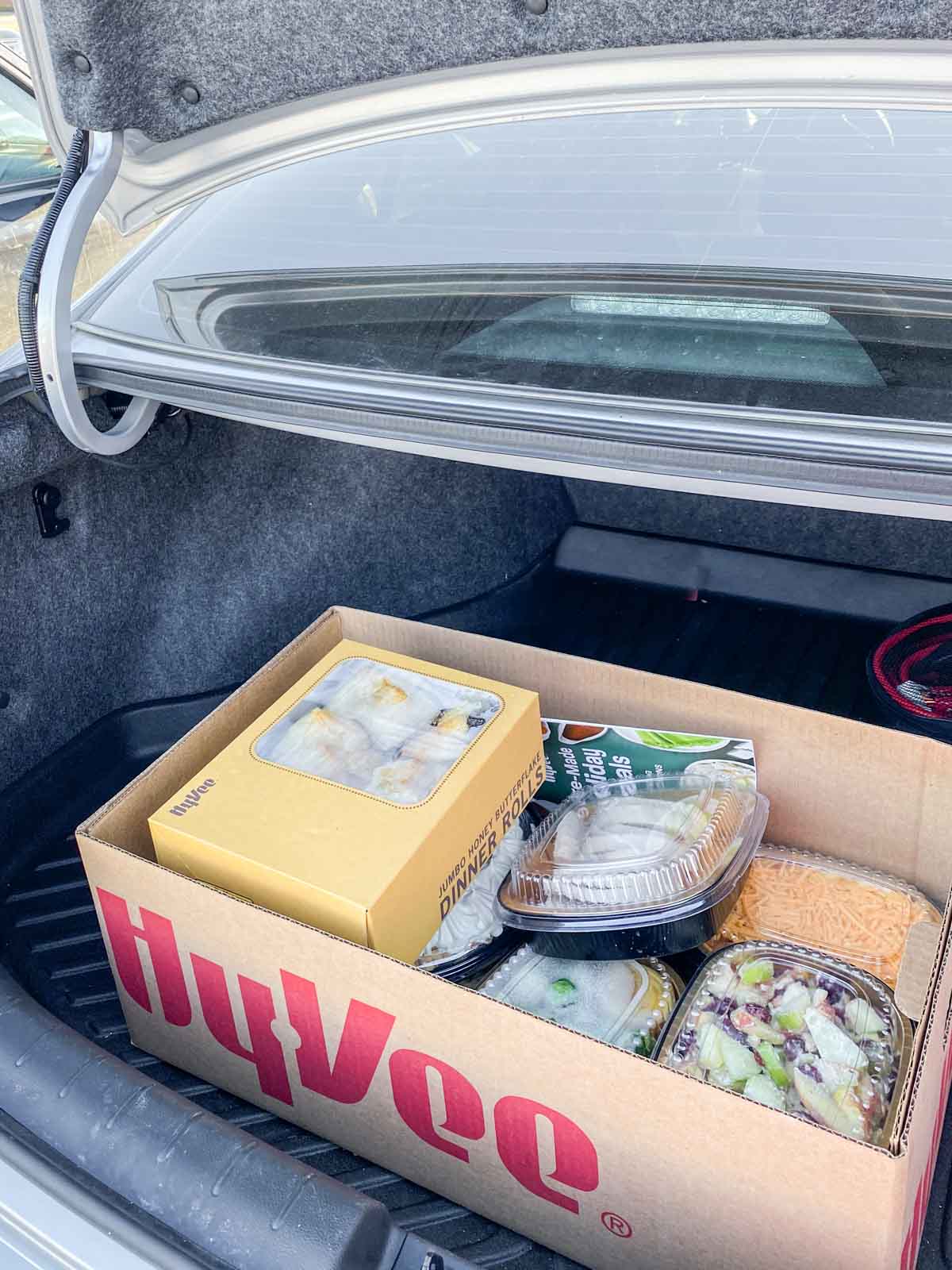 Hyvee box with food in the back of a trunk