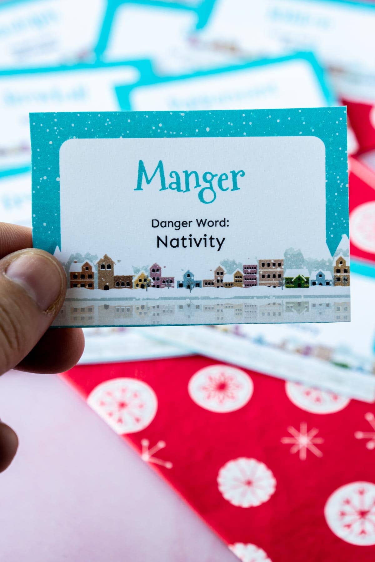 Woman's hand holding a card that says manger