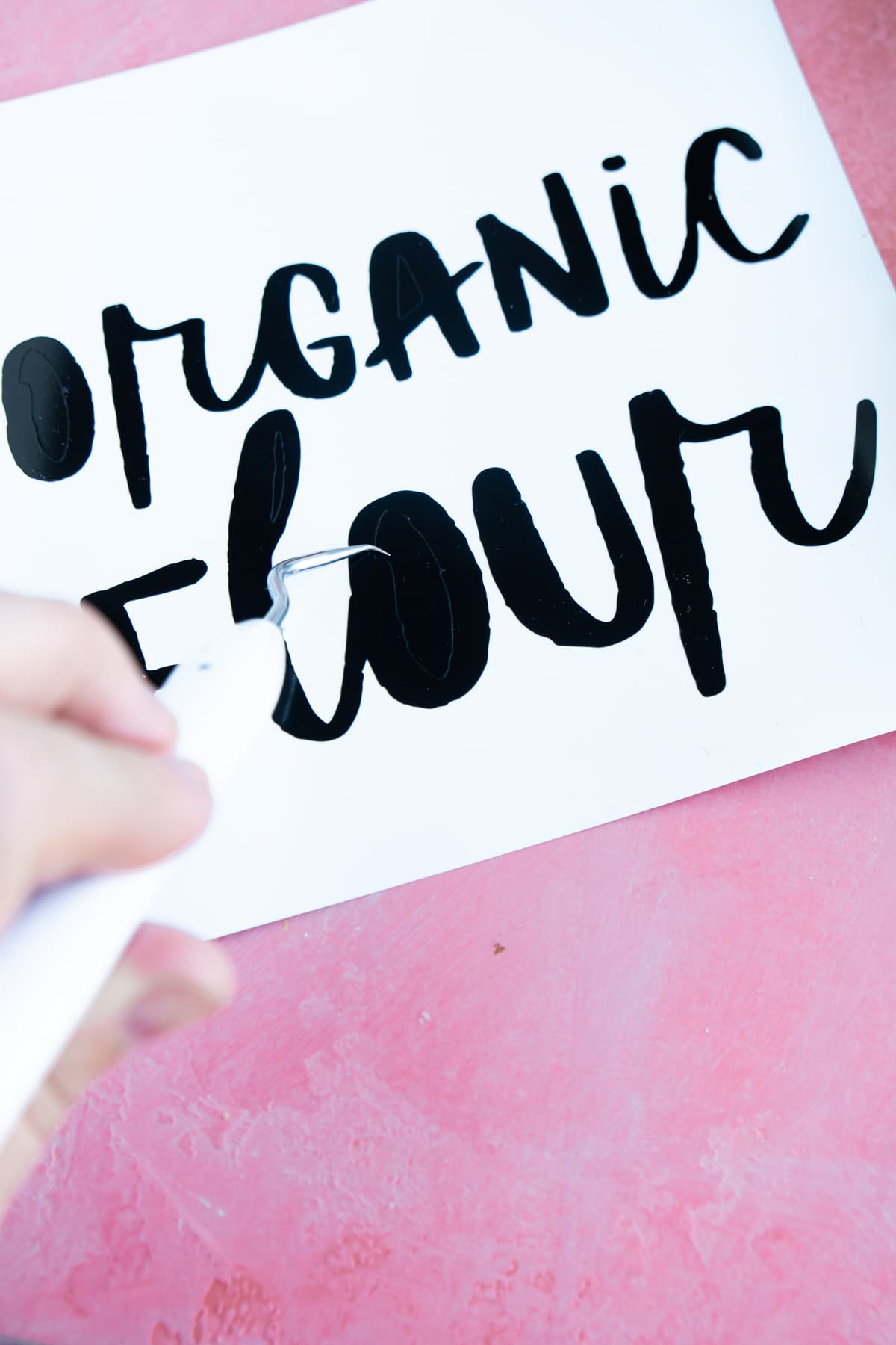 Organic flour vinyl label with a woman's hand holding a weeder