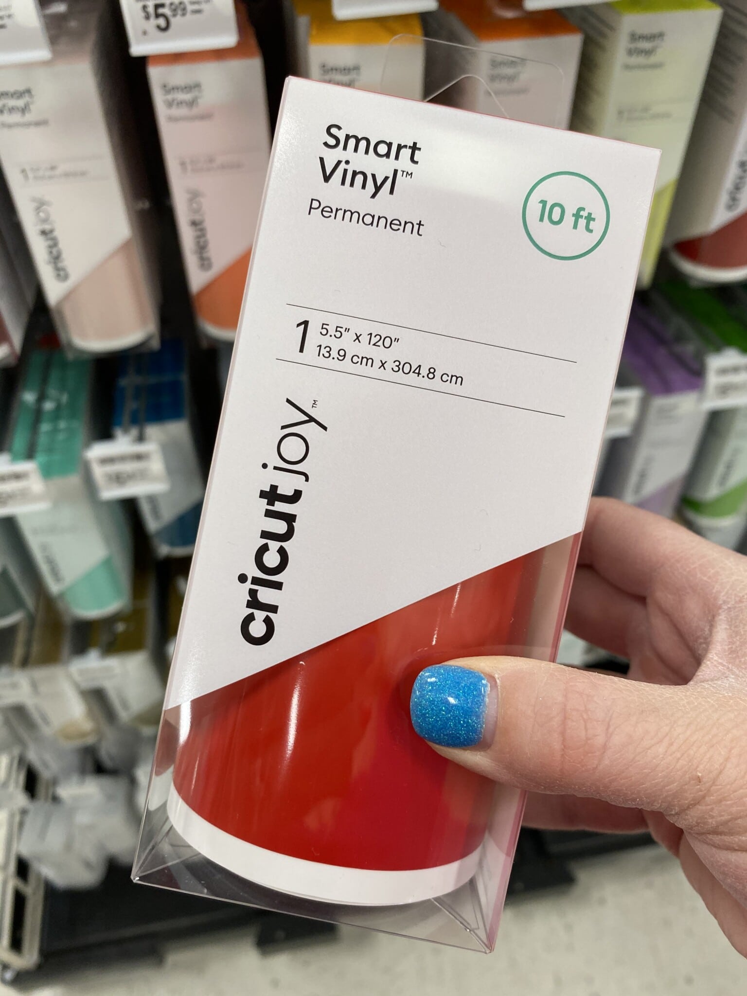Hand holding a red Cricut smart vinyl roll
