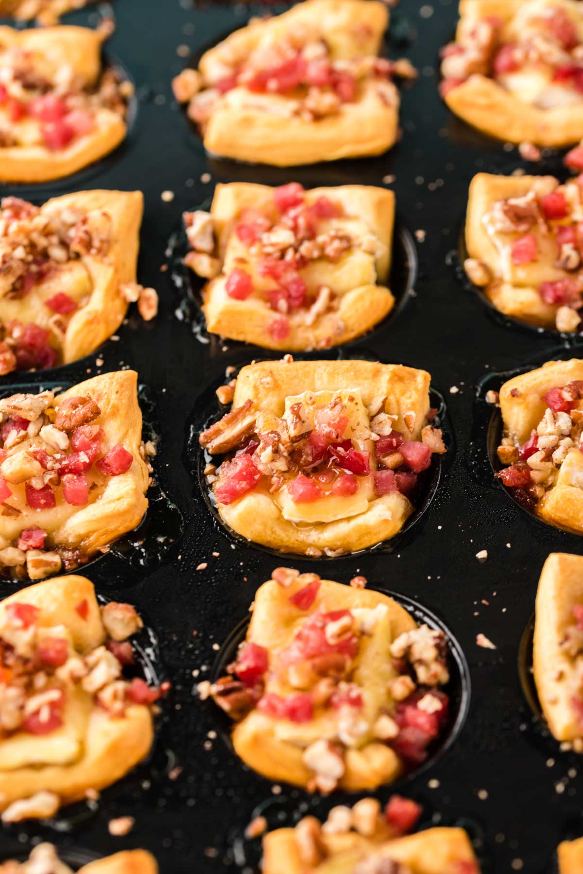 A muffin tin filled with bacon brie bites