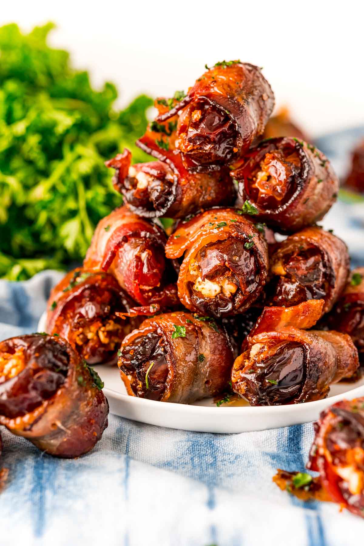 PIle of bacon wrapped dates on a white plate