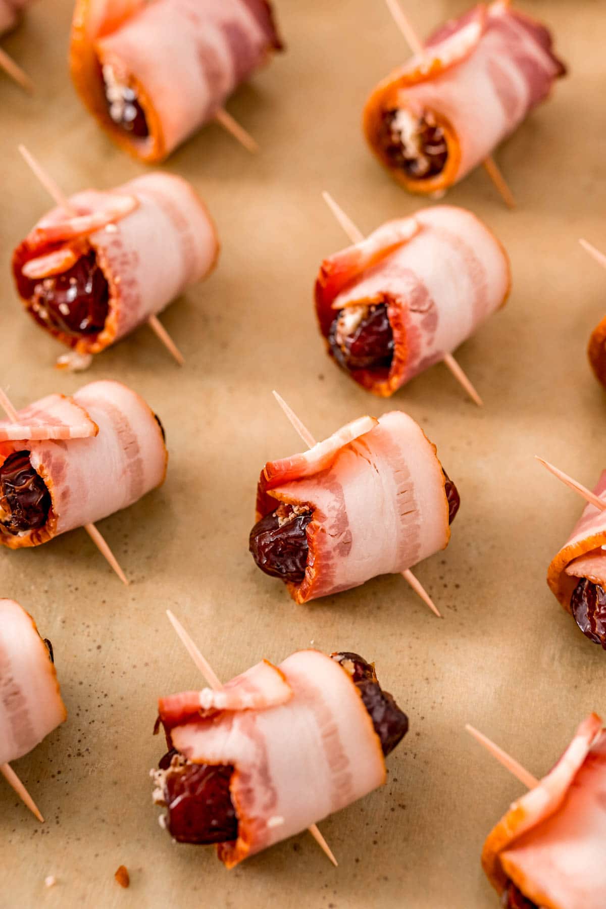 Bacon wrapped dates on a baking sheet