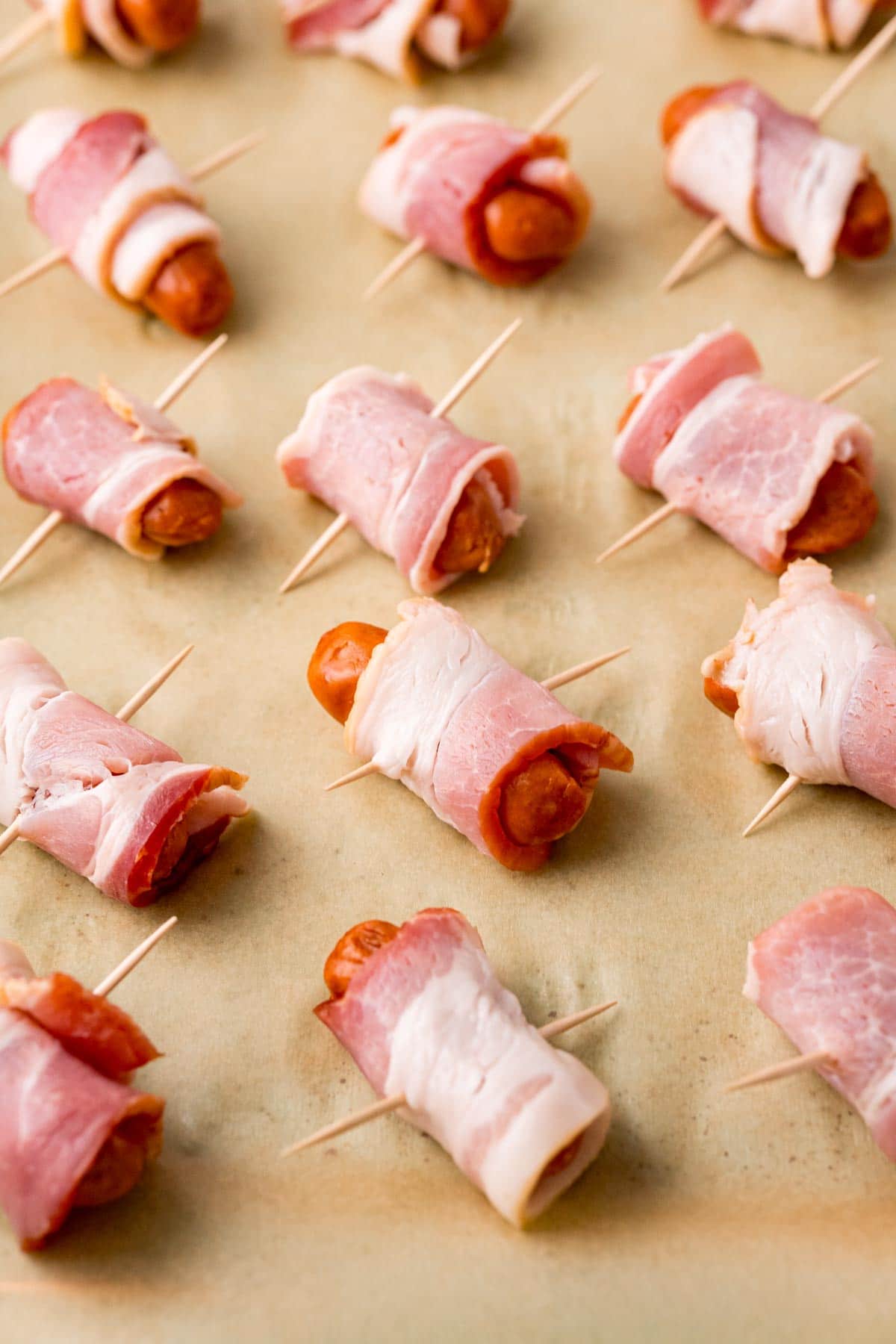 Bacon wrapped smokies on a piece of parchment paper