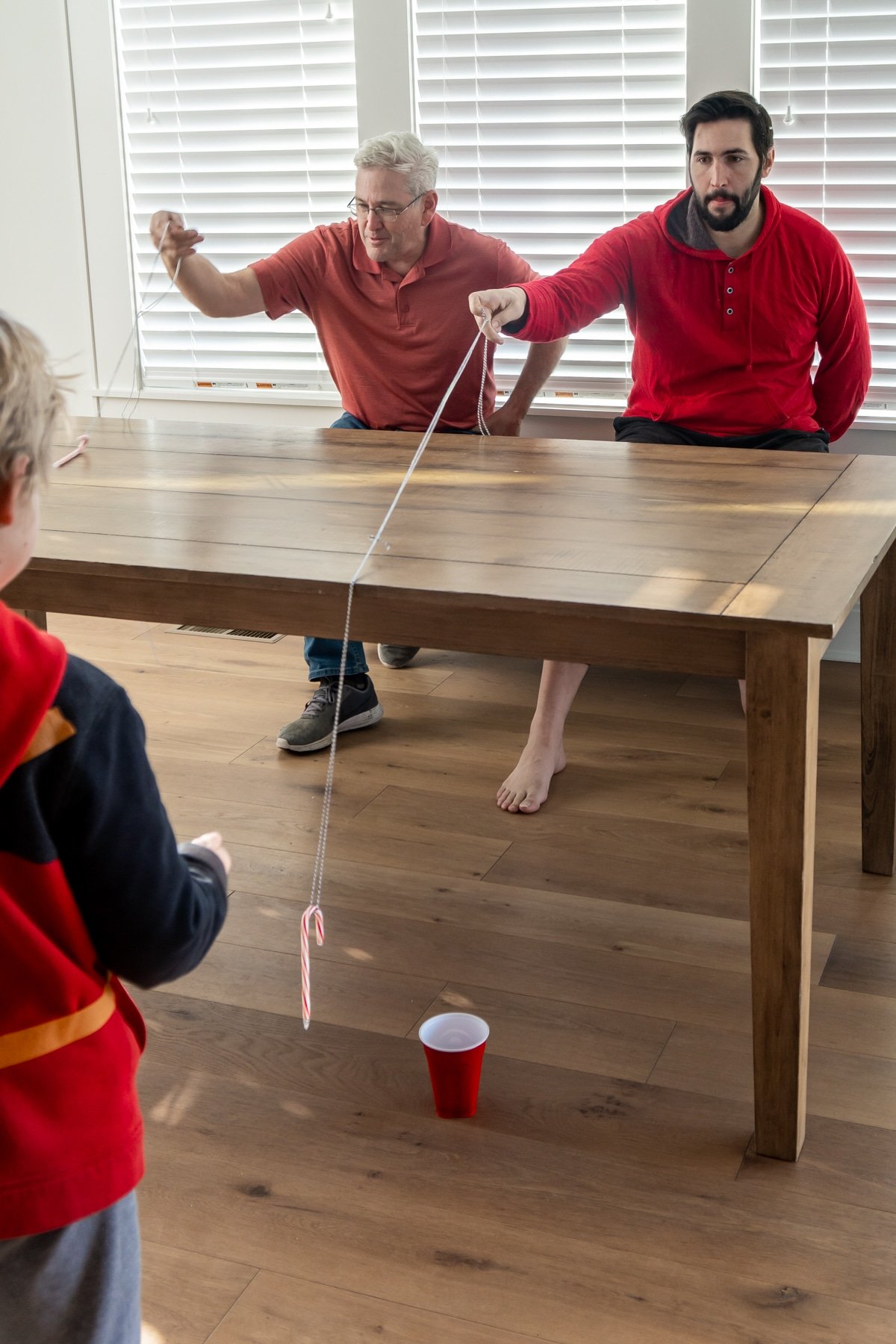 Two men on one side of the table with strings