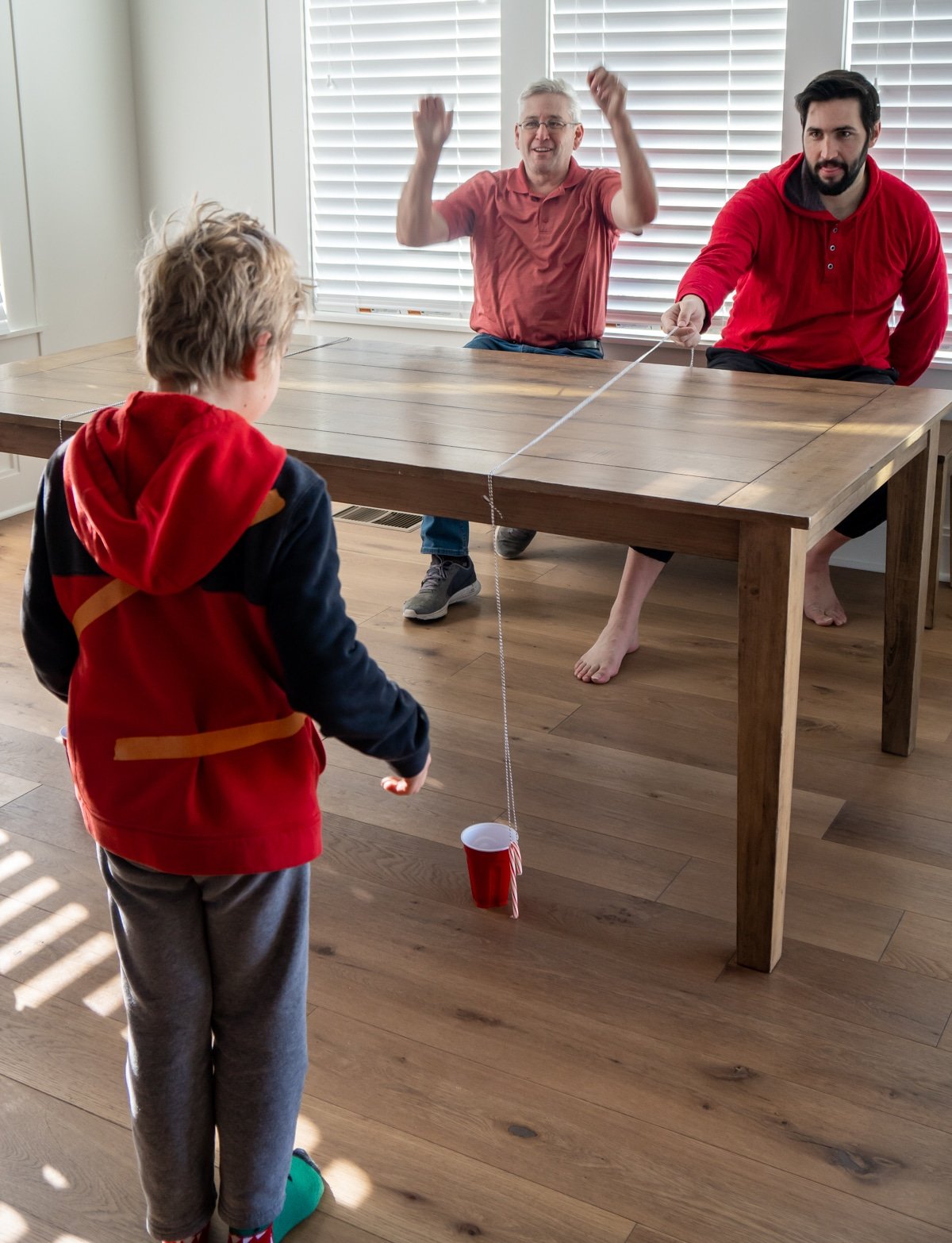 Man cheering with a boy on the other side of the table