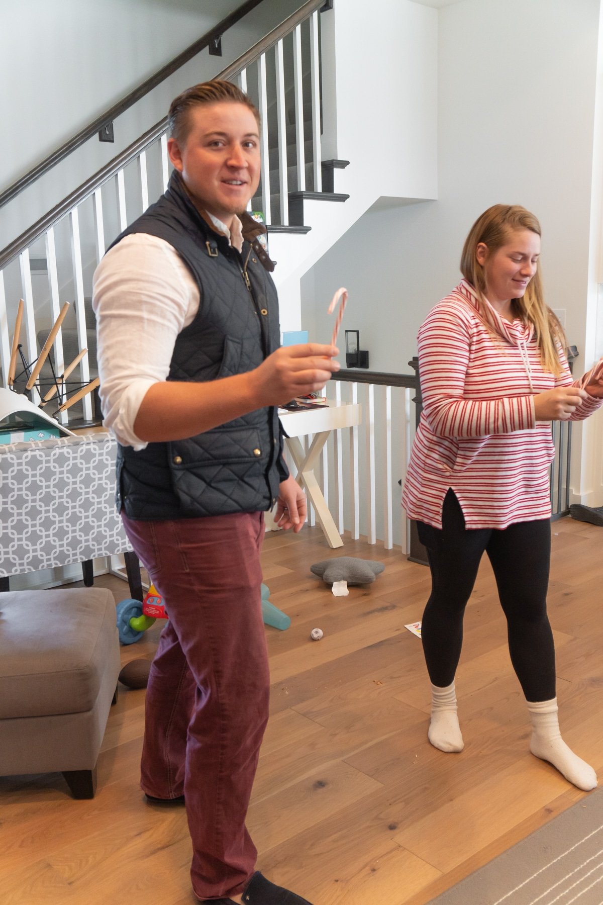 Man and woman holding candy canes