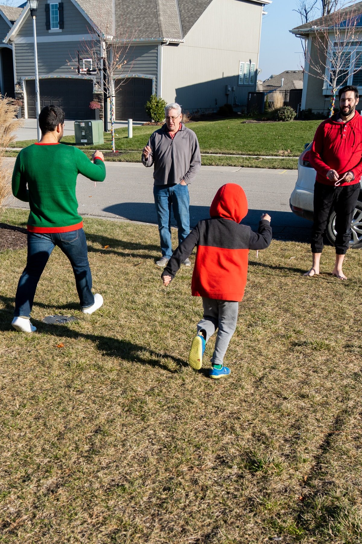 Four people running in a front yard