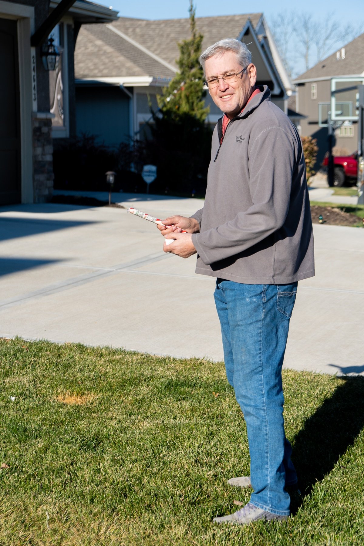 Man holding a candy cane stick and marshmallow