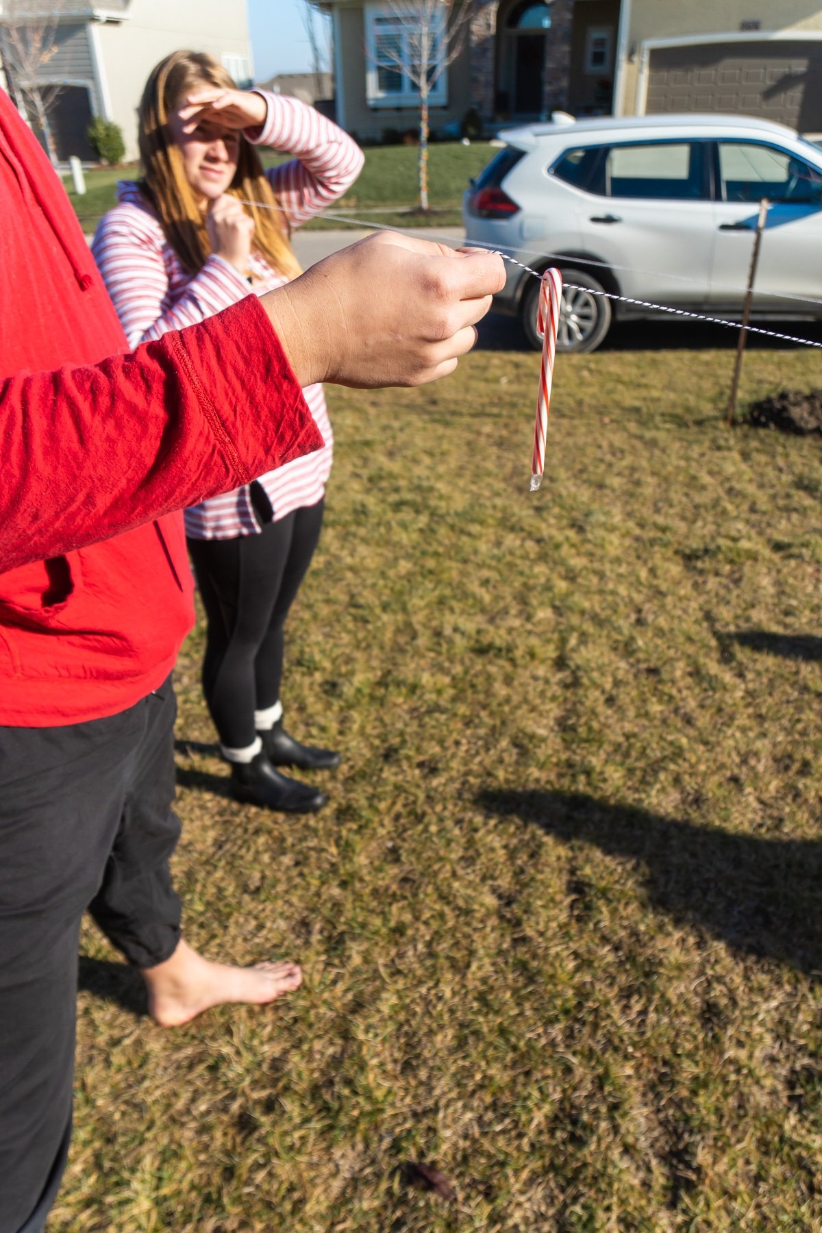 Man holding a string with a candy cane on it