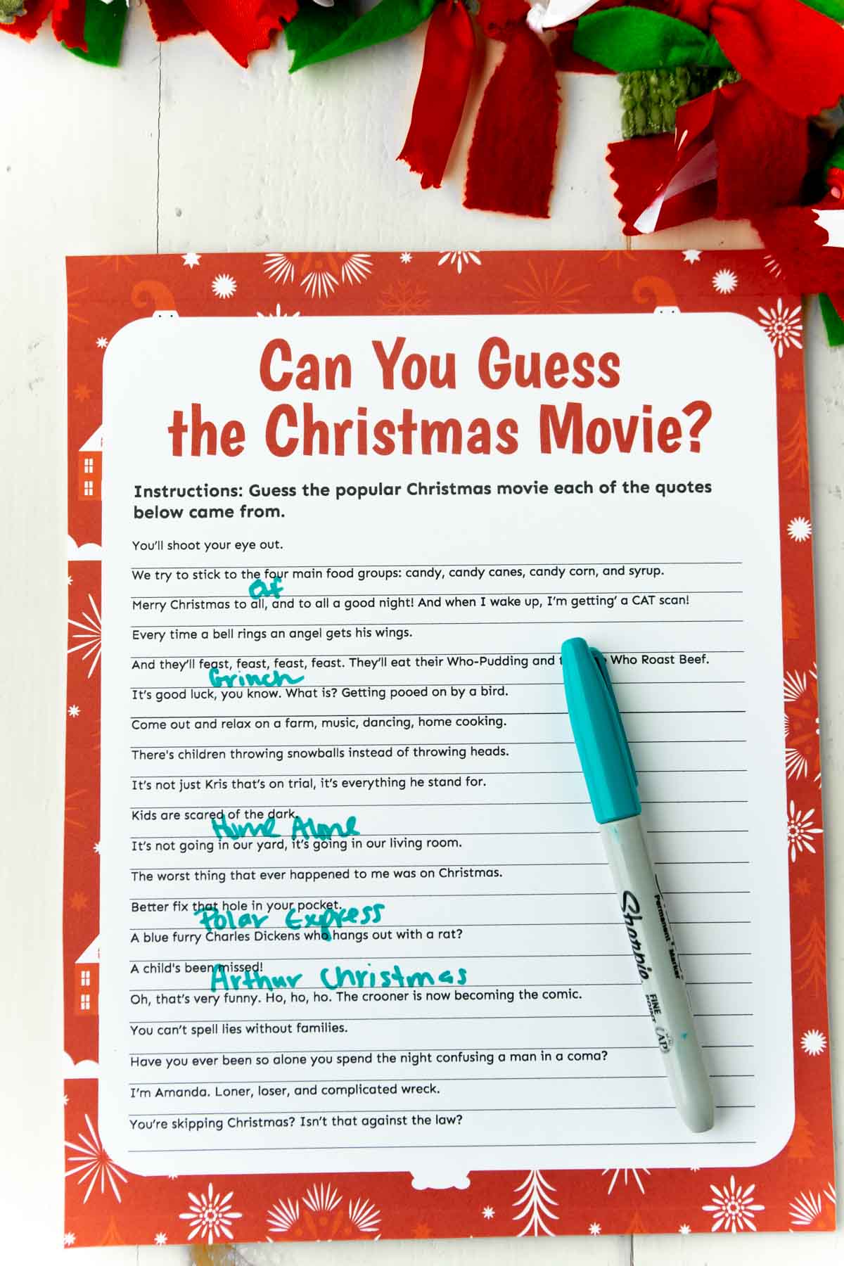 A Christmas movie trivia game with a green pen on top