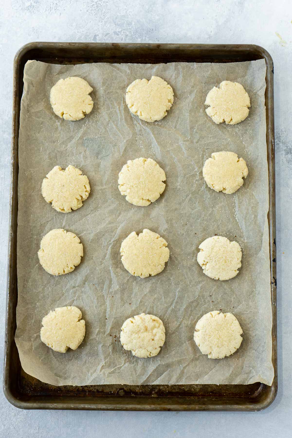 Baking sheet with orange sugar cookies ready to be baked